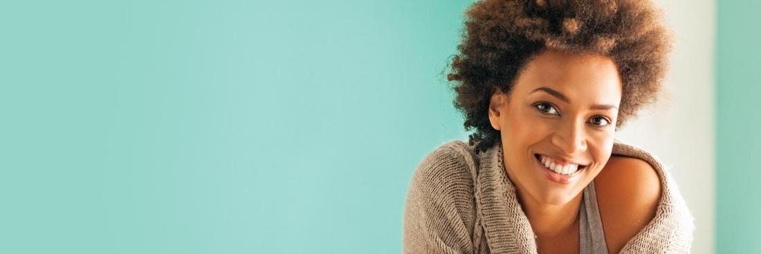 Woman smiling with blue background | Therapist Seattle WA