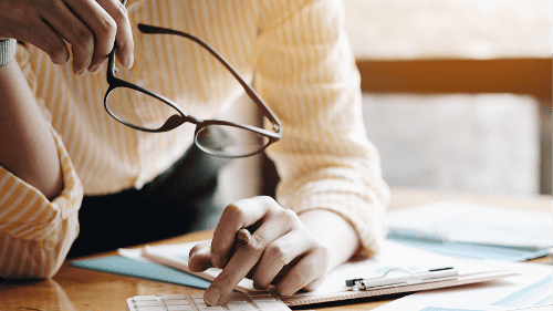 Person with calculator looking at finances