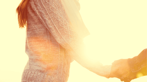 Woman holding partner's hand in sunlight